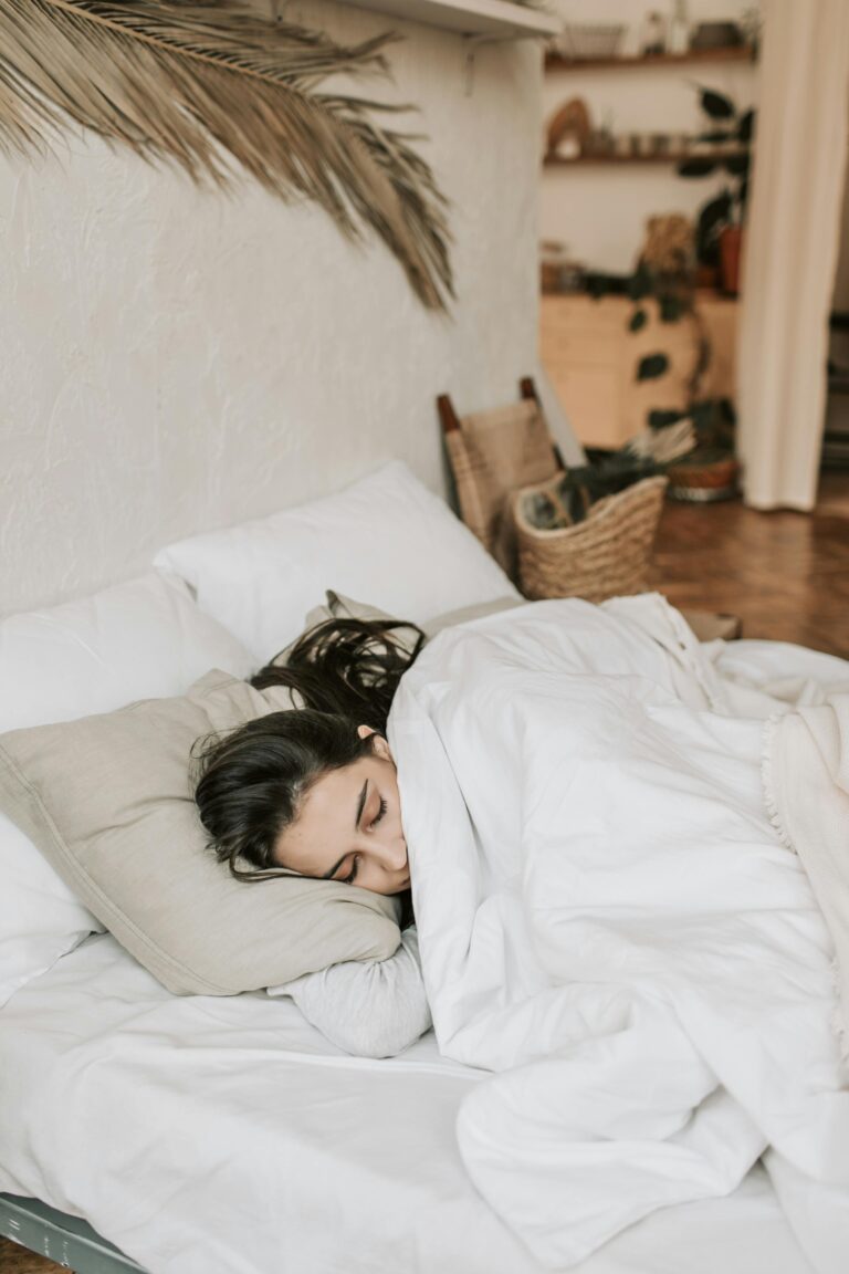 A peaceful woman sleeping on a comfortable bed, illustrating the importance of rest for better health and well-being.